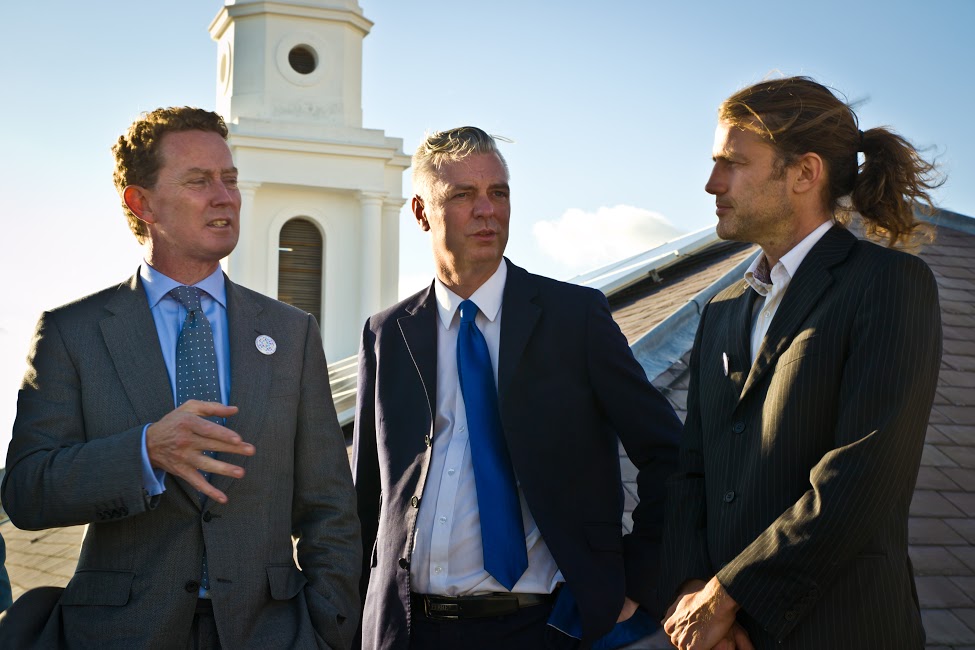 L-R: DECC Minister Greg Barker; Kemptown MP Simon Kirby; BEC Chairman Will Cottrell discuss community energy in front of a BEC solar system on St George’s Church, Kemptown. 6/9/13.