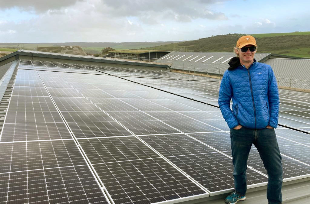 A man standing next to solar panels